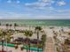 Scenic beach view with picnic area, boardwalk access, clear water, and palm trees under a blue sky at 315 Medallion Blvd # E, Madeira Beach, FL 33708