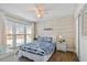 Bright bedroom with wood paneled wall, ceiling fan, and coastal-themed decor at 315 Medallion Blvd # E, Madeira Beach, FL 33708