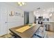 Bright dining area featuring a large wooden table, and white kitchen with stainless steel appliances in the background at 315 Medallion Blvd # E, Madeira Beach, FL 33708