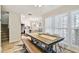 Dining room with a long wooden table, bench seating, and a view into the modern white kitchen area at 315 Medallion Blvd # E, Madeira Beach, FL 33708