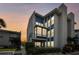 Beautiful 3-story condo building with blue trim and lots of large windows at dusk at 315 Medallion Blvd # E, Madeira Beach, FL 33708