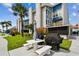 Building exterior with a lush green lawn and a white picnic table and grill at 315 Medallion Blvd # E, Madeira Beach, FL 33708