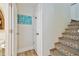 Hallway with decorative stairs, a coastal-themed sign, and access to a bathroom featuring a white door at 315 Medallion Blvd # E, Madeira Beach, FL 33708