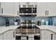 This kitchen features stainless steel appliances, white cabinets, modern tile backsplash and a stainless steel range at 315 Medallion Blvd # E, Madeira Beach, FL 33708