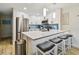 Bright kitchen boasts stainless appliances, white cabinets, counter seating, and modern pendant lighting at 315 Medallion Blvd # E, Madeira Beach, FL 33708