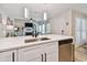 Kitchen view of the living area with stainless steel dishwasher, modern sink, white cabinets, and countertops at 315 Medallion Blvd # E, Madeira Beach, FL 33708