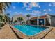 Community pool with lounge chairs and view of the clubhouse on a beautiful sunny day at 315 Medallion Blvd # E, Madeira Beach, FL 33708