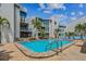 Community pool with lounge chairs and a view of the building's exterior on a sunny day at 315 Medallion Blvd # E, Madeira Beach, FL 33708