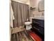 This bathroom has hardwood floors, a modern toilet and sink, and a shelf for decorations at 3217 W Lawn Ave, Tampa, FL 33611