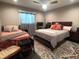 A large bedroom featuring multiple beds, a ceiling fan, and natural lighting at 3217 W Lawn Ave, Tampa, FL 33611
