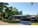 Charming single-story home with vibrant orange door, landscaped lawn, and paved driveway at 3217 W Lawn Ave, Tampa, FL 33611