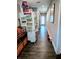 Hallway with hardwood floors, a refrigerator with decor, and a well lit front door at the end at 3217 W Lawn Ave, Tampa, FL 33611