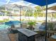 The beautiful screened patio includes a pool, comfortable seating, an outdoor kitchen, and an outdoor dining area at 3217 W Lawn Ave, Tampa, FL 33611