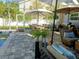 A comfortable patio features a grill, dining table, seating, lush landscaping, and a refreshing pool at 3217 W Lawn Ave, Tampa, FL 33611