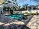 Stunning pool features sleek pavers, water feature, and refreshing blue water inside of a screened enclosure at 3217 W Lawn Ave, Tampa, FL 33611