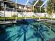 Sparkling in-ground pool has a water feature and is surrounded by a screened enclosure and grassy backyard at 3217 W Lawn Ave, Tampa, FL 33611