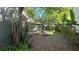 Landscaped backyard featuring mature trees and foliage, complemented by a comfortable lounge chair at 3527 Greenglen Cir, Palm Harbor, FL 34684