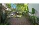 Landscaped backyard featuring mature trees and foliage, complemented by a comfortable lounge chair at 3527 Greenglen Cir, Palm Harbor, FL 34684
