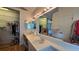 Bathroom featuring dual sinks and a walk in closet with mirrored doors at 3527 Greenglen Cir, Palm Harbor, FL 34684