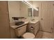Cozy bathroom featuring a toilet, white tiling, sink, vanity, mirror, and neutral decor with open linen storage at 3527 Greenglen Cir, Palm Harbor, FL 34684