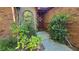 Close up of front door surrounded by lush landscaping and brick exterior with a decorative window at 3527 Greenglen Cir, Palm Harbor, FL 34684
