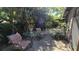 Outdoor patio featuring a glass table with comfortable striped chairs surrounded by lush plants and greenery at 3527 Greenglen Cir, Palm Harbor, FL 34684