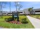 Prestwick condo building featuring well-manicured landscaping, sidewalk, and lush greenery at 36750 Us 19 N # 20211, Palm Harbor, FL 34684