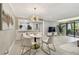 Bright living space with a modern dining table and light grey flooring leading to the balcony at 36750 Us 19 N # 20211, Palm Harbor, FL 34684