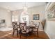Dining room with decorative chandelier, six chairs, and natural light coming through the arched windows at 4235 Wharton Way, Land O Lakes, FL 34639