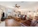 Spacious living room with ceiling fan, fireplace, and leather couches at 4235 Wharton Way, Land O Lakes, FL 34639