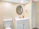 A well-lit half bathroom with a modern vanity, round mirror, and toilet, offering convenience and style at 4316 Sunray Ct # 34, Tampa, FL 33615