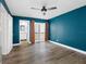 Teal bedroom with wood-look floors, balcony access, and entry to the en-suite bathroom at 4316 Sunray Ct # 34, Tampa, FL 33615