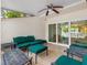 Charming outdoor porch with wood-look tiled flooring and dark green seating with ceiling fan at 4316 Sunray Ct # 34, Tampa, FL 33615