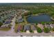 Scenic aerial view of a residential neighborhood featuring multiple homes and a tranquil lake at 4839 Pointe O Woods Dr, Wesley Chapel, FL 33543