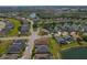 Beautiful aerial shot of a community with well-maintained streets and landscaping nestled by a lake at 4839 Pointe O Woods Dr, Wesley Chapel, FL 33543