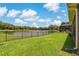 Expansive backyard with lush lawn and beautiful lake view, enclosed by a sleek black fence at 4839 Pointe O Woods Dr, Wesley Chapel, FL 33543