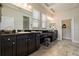 Large bathroom featuring dual sinks, tile floors, granite countertops, and a separate powder room at 4839 Pointe O Woods Dr, Wesley Chapel, FL 33543