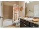Well-lit bathroom featuring a shower-tub combination with stylish nautical-themed shower curtain at 4839 Pointe O Woods Dr, Wesley Chapel, FL 33543