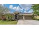 Beautiful single-story home with a well-manicured lawn, mature landscaping, and a two-car garage at 4839 Pointe O Woods Dr, Wesley Chapel, FL 33543