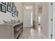Inviting home foyer featuring neutral walls, tile floors, and a decorative shelf at 4839 Pointe O Woods Dr, Wesley Chapel, FL 33543