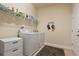 Well-organized laundry room featuring a white washer and dryer, storage bins, and ample shelving at 4839 Pointe O Woods Dr, Wesley Chapel, FL 33543