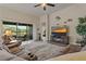 Inviting living room featuring a plush sectional sofa, fireplace, and sliding doors to an outdoor patio with lake views at 4839 Pointe O Woods Dr, Wesley Chapel, FL 33543