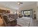 Comfortable living room with a large sofa, leading to an outdoor seating area through sliding glass doors at 4839 Pointe O Woods Dr, Wesley Chapel, FL 33543