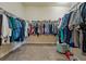 Large walk-in closet with ample hanging space and storage shelves for shoes and folded clothing at 4839 Pointe O Woods Dr, Wesley Chapel, FL 33543