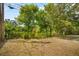 Backyard view featuring lush trees, direct access to a serene lake, and natural landscaping at 5050 68Th N Way, St Petersburg, FL 33709