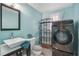 Modern bathroom with vanity sink, contemporary washing machine, decorative shelving, and a modern toilet at 5050 68Th N Way, St Petersburg, FL 33709