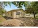 Exterior view of the house with a yard and mature trees at 5050 68Th N Way, St Petersburg, FL 33709