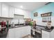 Cozy kitchen with white cabinetry, stainless steel appliances, and black countertops at 5050 68Th N Way, St Petersburg, FL 33709