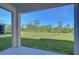 An outdoor back porch with a view of an expansive lawn and lush greenery under a clear, sunny sky at 5325 Thistle Field Ct, Wesley Chapel, FL 33545