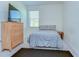 Cozy bedroom featuring a comfortable bed, dresser, bedside table, and a large window with natural light at 5325 Thistle Field Ct, Wesley Chapel, FL 33545